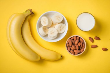 Sarı zemin üzerine bir bardak taze yapılmış muz smoothie
