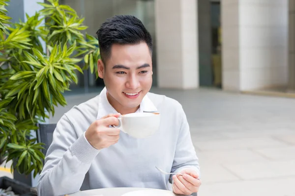 Guapo joven bebiendo café en la ciudad — Foto de Stock