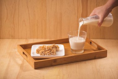 süt dökün şişe, badem şekerleri ahşap arka plan üzerinde