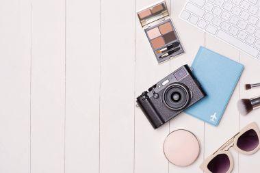 Kozmetik kadın ve moda öğeleri ile fotoğraf makinesi ve pasaport masada. Üstten Görünüm