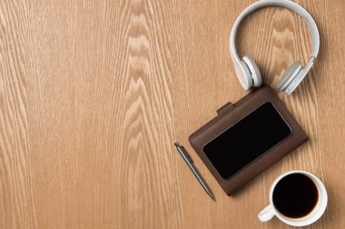 Ofis masaları ile smartphone, kulaklık ve kahve. Üst görüntülemek wi