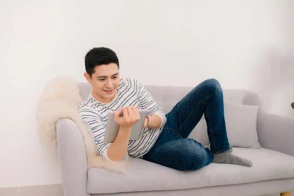 Asiatique Jeune Homme Relaxant Sur Canapé Avec Tablette Numérique — Photo