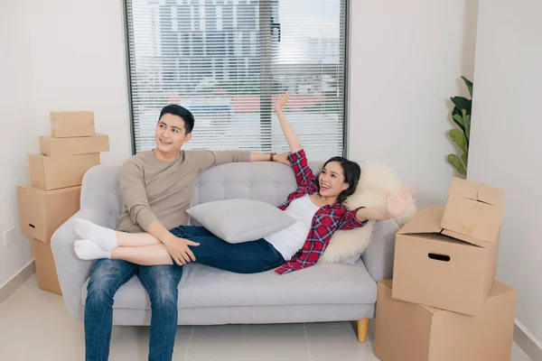 Couple planning decoration new home sitting on sofa in living room
