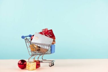 Noel alışveriş kavramı. Alışveriş sepeti Noel hediye kutuları ve kredi kartı ile dolu.