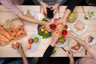 Arkadaşlarınızla akşam yemeği zevk. Grup birlikte ahşap masada otururken yemeğe insan Üstten Görünüm