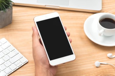 Telefon kullanarak ele yakın çekim. Smartphone şablon ofis masasında sahte.