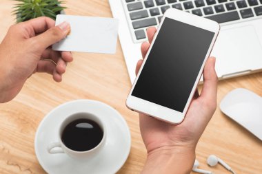 Kredi kartı, klavye, smartphone ve masada kahve fincanı.