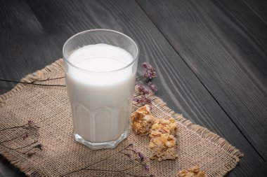 Süt ve süt ürünleri. Bir bardak süt hizmet rustik ahşap bir masa üzerinde badem şekerleri ile.