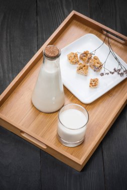 Şişe süt ve süt badem şekerleri ile ahşap masa.