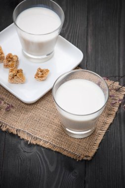 Süt ve süt ürünleri. Bir bardak süt hizmet rustik ahşap bir masa üzerinde badem şekerleri ile.