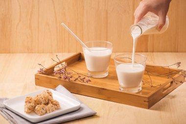 süt dökün şişe, badem şekerleri ahşap arka plan üzerinde