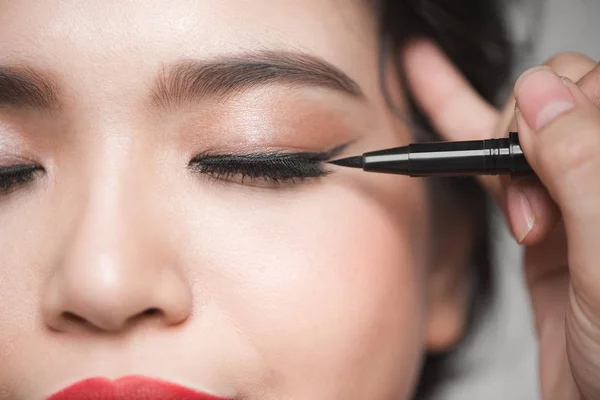 Chica tocando el delineador de ojos negro para el párpado — Foto de Stock