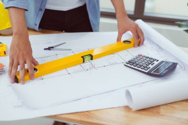 Laptop ve planları ile çalışan mimar adam