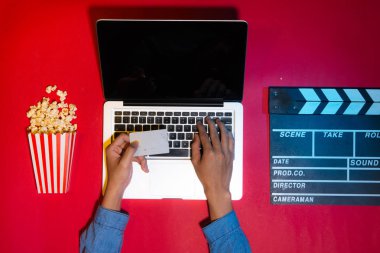 Patlamış mısır ve fıçı tahtası ile online bilet ödeme kredi kartı tutan adam. Filmler ve sinema kavramı