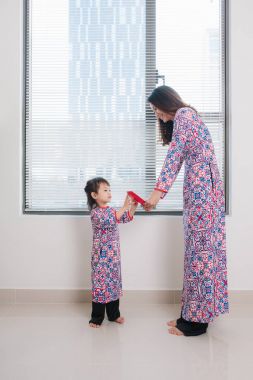Vietnamca anne ve kızı Ao Dai geleneksel elbiseli kutlama yeni yıl evde. Tet Bayramı tatil.