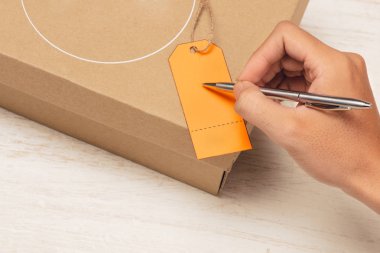 Erkek el Bagaj etiketinde kahverengi kağıt parsel üzerinde yazma