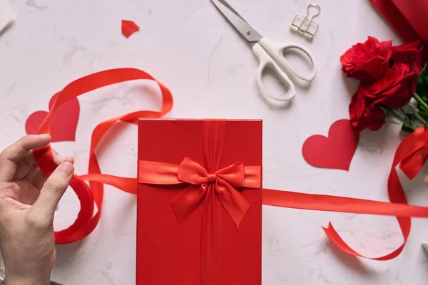 Mãos Masculinas Embrulhando Valentine Presente Artesanal Papel Com Fita Vermelha — Fotografia de Stock