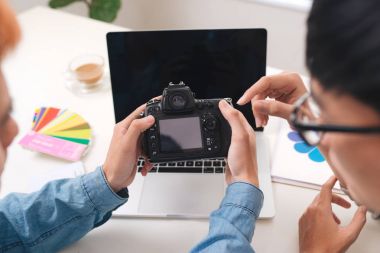Kamera masada oturan Studio bakarak fotoğraf editörleri