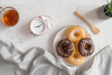 Tablo üzerinde saat ve kahve fincanı çörek ile görünümünü top. Sabah kahvaltı.