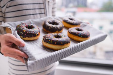 Bir tepsi Donuts holding erkek eller