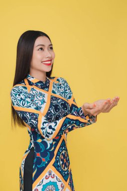 Sarı arka plan üzerinde izole geleneksel kostüm giyen çekici Vietnamca kadın