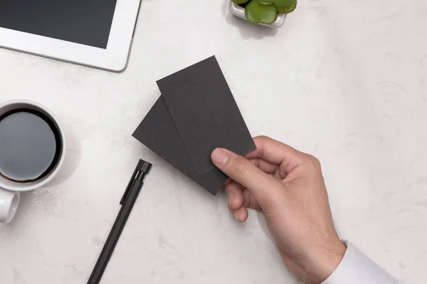 Mockup of black business cards in man's hand