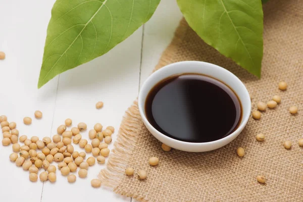 Soy sauce and soy bean on wooden table