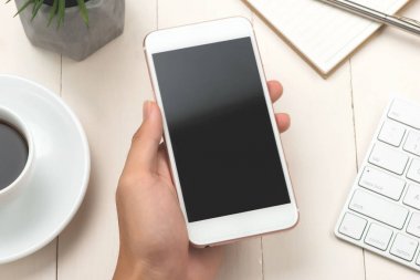 Telefon kullanarak ele yakın çekim. Smartphone şablon ofis masasında sahte.