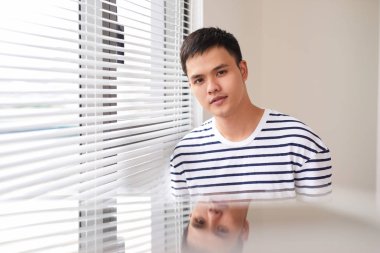 Sabah pencerenin kenarında duran genç adam