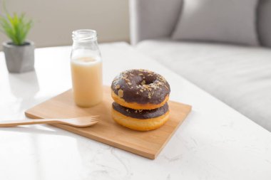 Çikolatalı çörek. Sabah kahvaltısı masada oturma odasında evde süt ile.