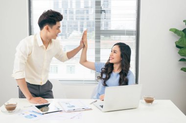 Bir dizüstü bilgisayar üzerinde genç tasarımcılar iki iş arkadaşlarınızla eğlenceli tartışırken modern ofiste çalışan birkaç proje