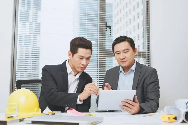 Architect (or real estate agent) discussing work with blueprints — Stock Photo, Image