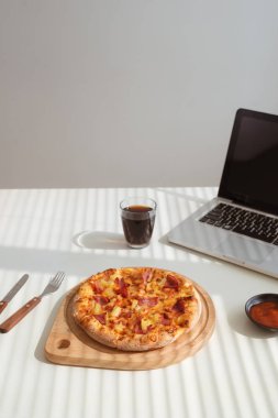 Kola ve dizüstü bilgisayar, lokanta ile ofis masasında lezzetli pizza
