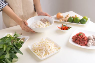 Kadın Şef geleneksel Vietnam çorba Pho bo otlar, et, Pirinç Noodle ile hazırlama