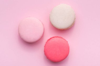 Pembe ve beyaz macarons üstten görünüm yumuşak tatlı pembe arka plan üzerinde