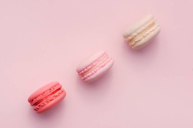 Pembe ve beyaz macarons üstten görünüm yumuşak tatlı pembe arka plan üzerinde