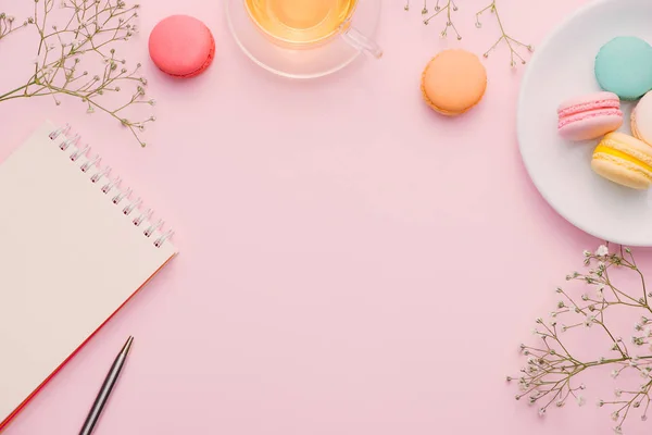 Kopje Thee Kleur Macarons Lege Kladblok Met Pen Bloemen Tafel — Stockfoto