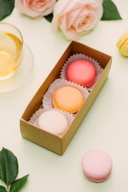 Renkli kurabiye hediye kutusu ve hafif tabloda çay ile gül. Üstten Görünüm