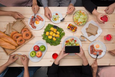 Arkadaşlarınızla akşam yemeği zevk. Grup birlikte ahşap masada oturmuş yemek yerken insan Üstten Görünüm