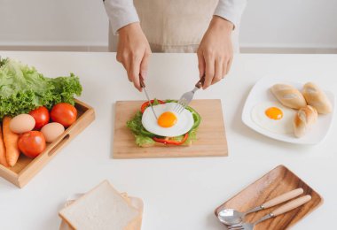 Adamın elleri ile haşlanmış yumurtalı sandviç kahvaltı hazırlamak