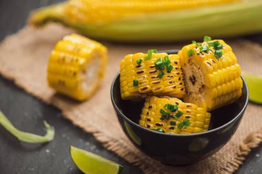 Siyah taş zemin üzerine soğan soslu lezzetli tatlı ızgara mısır.