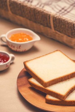 Masada bir plaka üzerinde çilek ve portakal reçelli tost.