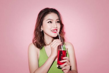 Asyalı kadın kırmızı softdrink içme kutluyor