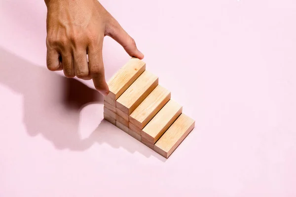 Başarı temel yapı kavramı. Erkek el ahşap blok merdiven şeklinde koymak.