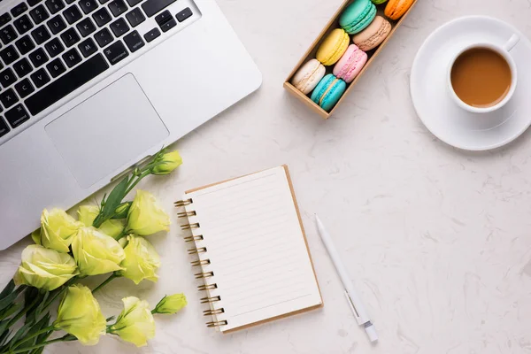 白色的办公桌与多彩杏仁饼 笔记本 笔记本和杯咖啡 — 图库照片