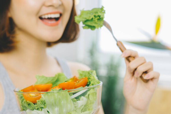 Young asian woman eating fresh vegetable salad. Loosing Weight concept