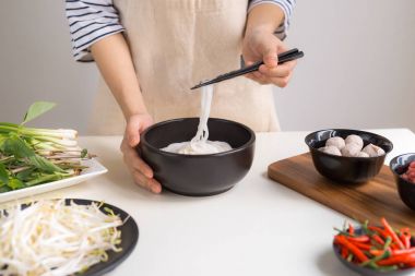Kadın Şef geleneksel Vietnam çorba Pho bo otlar, et, Pirinç Noodle ile hazırlama
