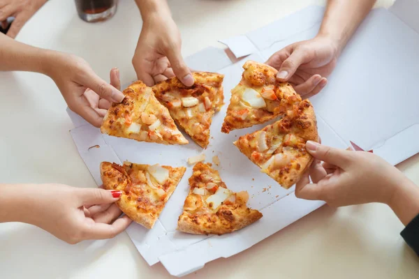 People eat fast food. Friends hands taking slices of pizza