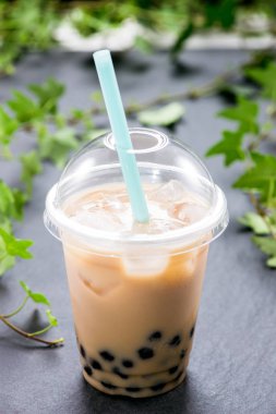 Ev yapımı süt kabarcık çay tablo üzerinde plastik kap içinde.