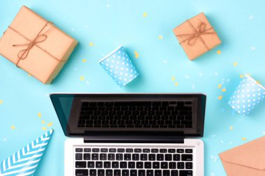 Hediye kutusu, doğum günü parti şeyler ve mavi bir arka plan üstünde laptop